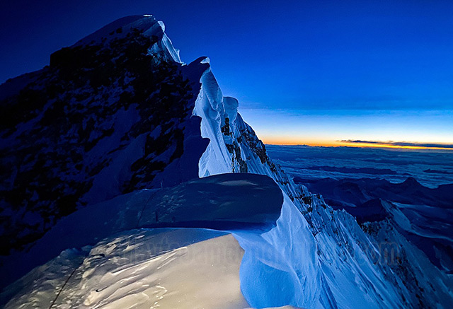 Mặt trời mọc lên từ đường chân trời phía sau Cornice Traverse gần đỉnh Mt. Everest 